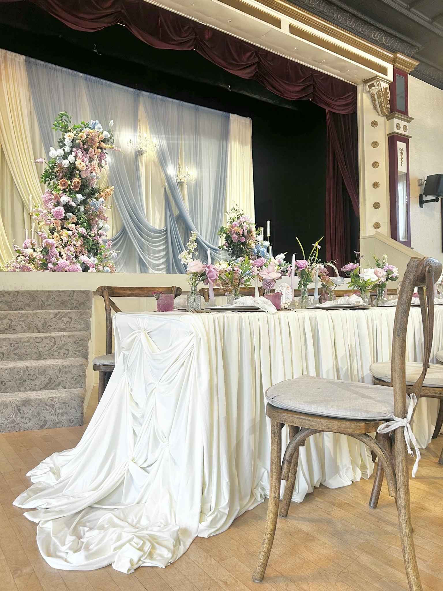 Signature Stage Setup custom structure with ivory, slate blue, and blush styling for a wedding at Marysville Opera House