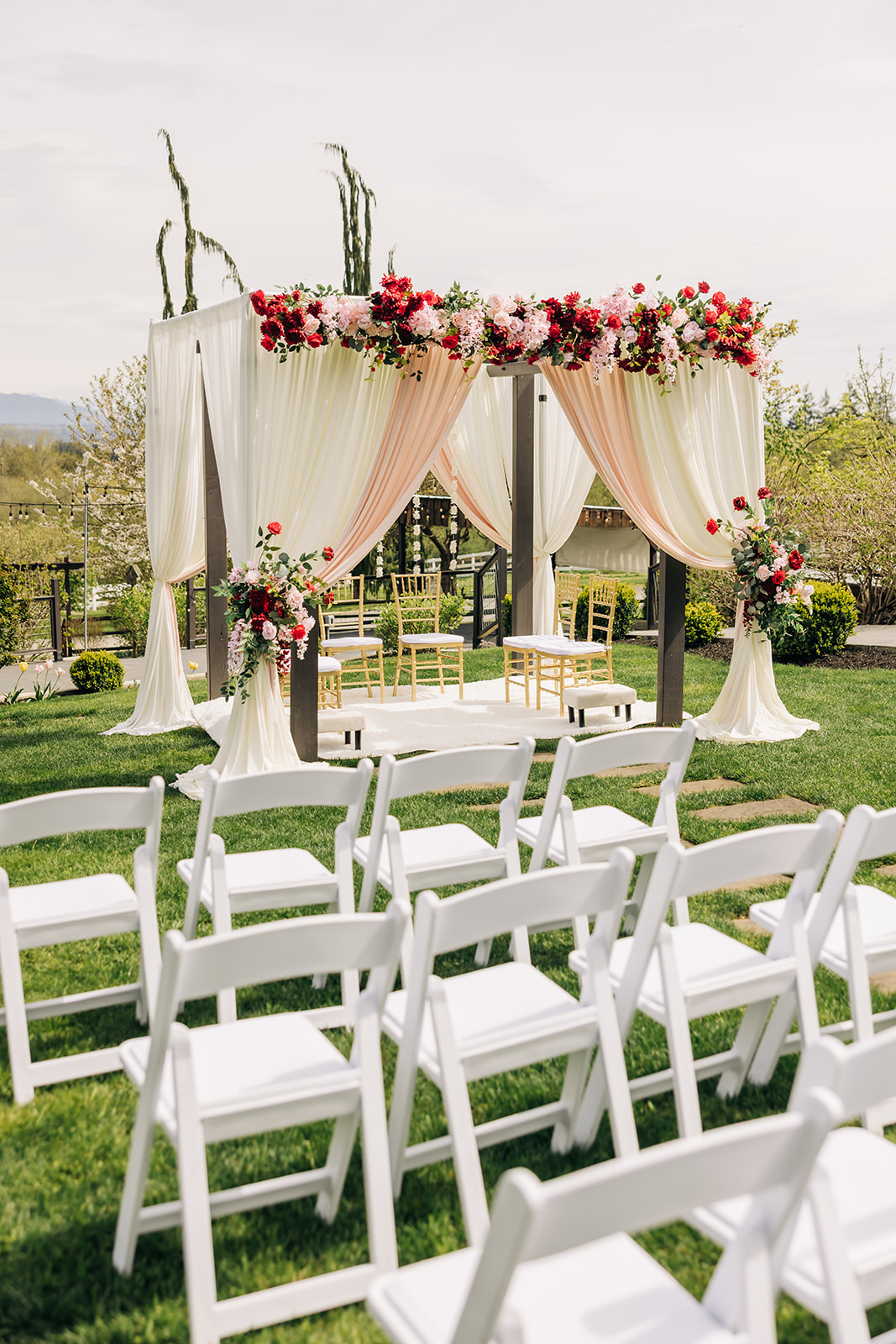 Mandap ceremony structure with blush drapery and red floral canopy for a Hindu wedding in the greater Seattle area