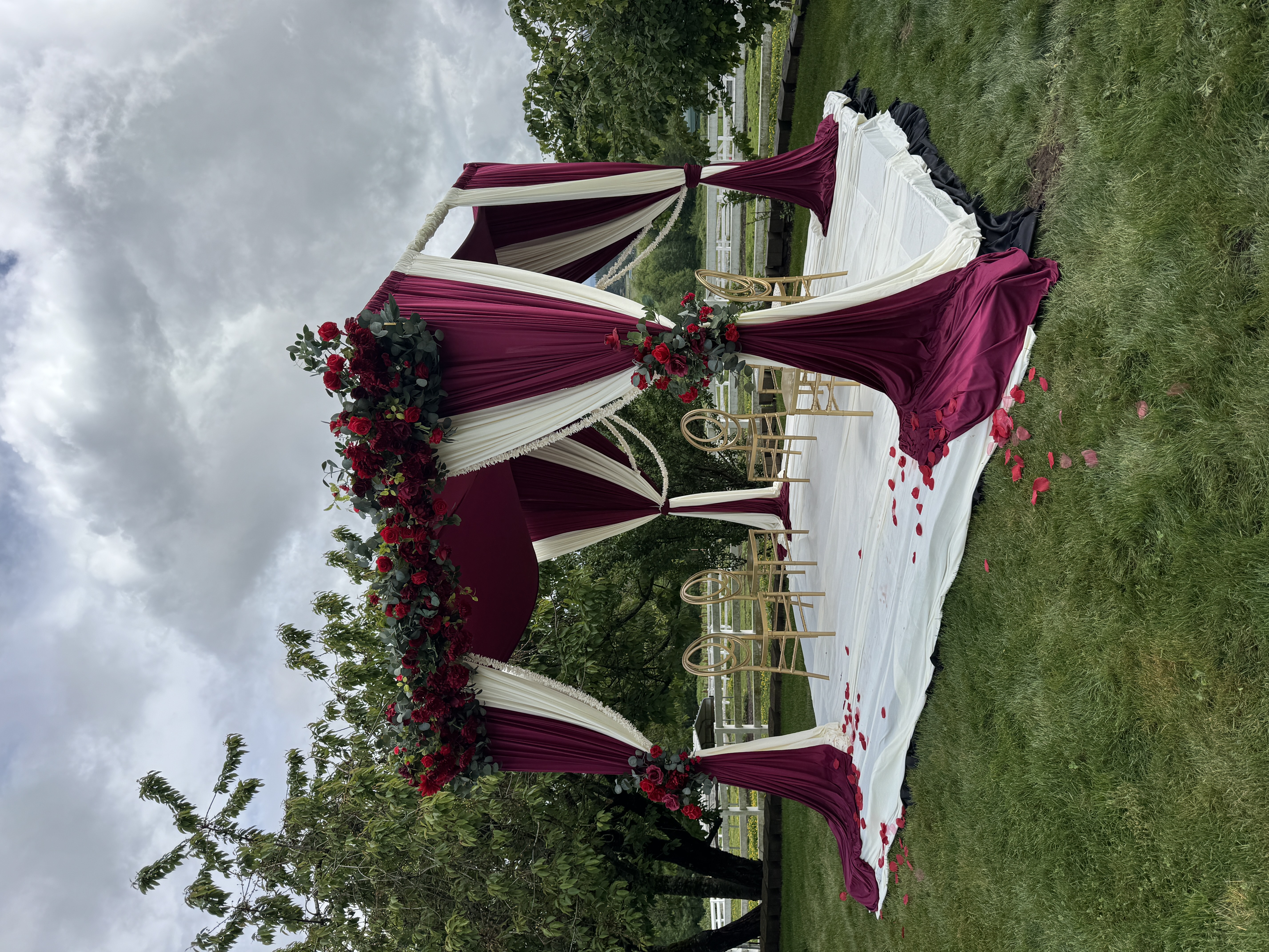 Mandap ceremony structure with blush drapery, red and pink floral canopy, and gold chiavari seating for a Hindu wedding in the greater Seattle area